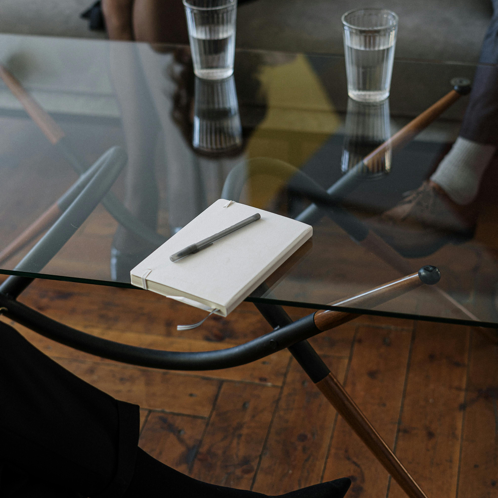 White and Silver Chair Beside Clear Drinking Glass on Glass Table